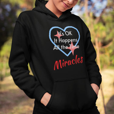 Gildan youth unisex hoodie with “Miracles Happen” design and uplifting message, Christian apparel made from soft preshrunk fleece, ideal for cooler weather and faith-inspired comfort, girl in black hoodie